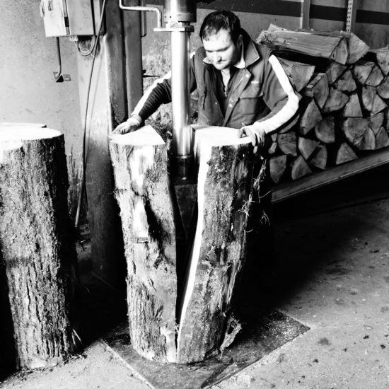 man splitting logs in factory